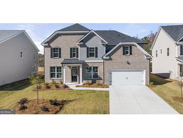 Charming two-story home featuring a brick facade, black shutters, and a well-manicured front lawn at 1809 Quaker, Hampton, GA 30228