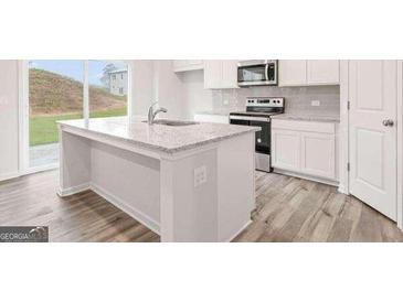 Modern kitchen with white cabinets, stainless steel appliances, and granite countertops, with wood-style floors at 8504 Polston Pl # 145, Douglasville, GA 30134