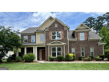 Charming two-story brick home with manicured lawn and inviting front entrance at 321 Champions Dr, Fairburn, GA 30213