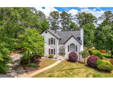 Charming two-story home featuring a well-manicured lawn, mature trees and lush landscaping at 9206 Denmeade Trce, Douglasville, GA 30135