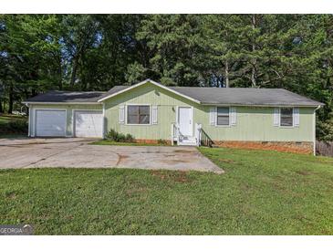 Charming single-story home featuring an attached two-car garage and a well-maintained front yard at 4954 Browns Mill Rd, Lithonia, GA 30038