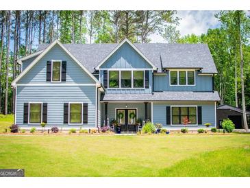 Charming two-story home with blue siding, black shutters, and a beautifully landscaped front yard at 457 Paynes Lake Rd, Carrollton, GA 30116