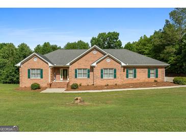 Charming brick home with green shutters, well-manicured lawn and beautiful landscaping at 604 Clearwater Ct, Mcdonough, GA 30252