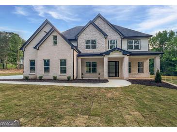 Beautiful new construction home featuring a covered porch, professional landscaping, and modern brickwork at 1465 Leach Dr, Lawrenceville, GA 30045