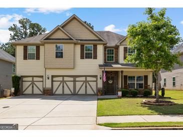 Charming two-story home with a three-car garage, covered porch, and manicured lawn at 71 Pacific Ave, Sharpsburg, GA 30277