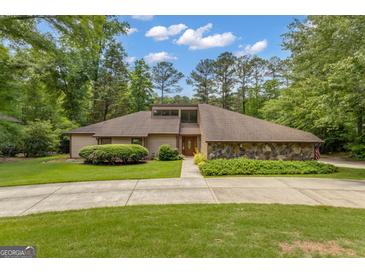 Charming single-story home with stone accents, inviting curb appeal, and a well-manicured lawn at 105 Gleneagles Pt, Peachtree City, GA 30269