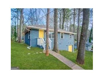 Quaint exterior view of home featuring a charming, painted blue facade with a bright yellow door at 4366 Glenwood Pkwy, Decatur, GA 30032