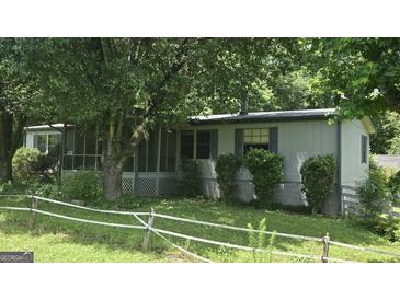 Charming single-story home with a screened-in porch and lush landscaping at 1100 Kinnett Rd, Covington, GA 30016