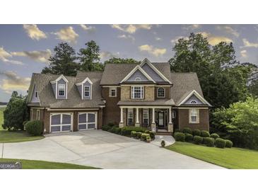 Charming two-story brick home with a well-manicured lawn, a two-car garage, and inviting front porch at 9742 Fallview Ct, Villa Rica, GA 30180