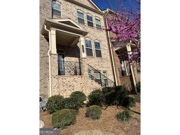 Charming brick townhome with landscaped front yard and a decorative black metal railing at 3608 Davenport Rd, Duluth, GA 30096