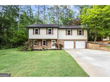 Charming two-story home featuring a well-manicured lawn and attached two-car garage at 2687 Fairfield Sw Dr, Marietta, GA 30064