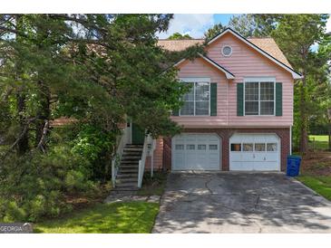 Charming two-story home with a two-car garage, framed by mature trees and a well-maintained lawn at 300 Fox Trail Dr, South Fulton, GA 30349