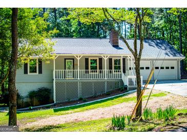 Charming single Gathering home with a manicured front lawn and a convenient two-car garage at 6026 Belle Meade Ct, Villa Rica, GA 30180