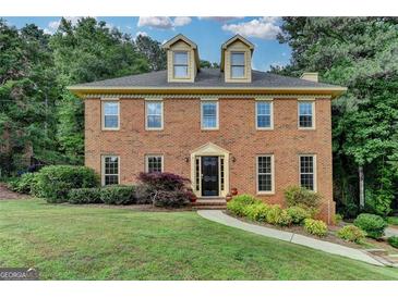 Charming two-story brick home featuring dormer windows and mature landscaping at 1486 Maple Ridge Dr, Suwanee, GA 30024