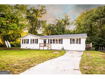 Charming home with a well-maintained yard, crisp white exterior, and inviting front porch entrance at 361 N Dogwood Ave, Social Circle, GA 30025