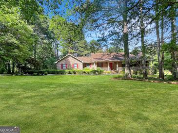 Charming brick home with lush lawn and mature trees offers great curb appeal at 120 Rolling Brook Trl, Fayetteville, GA 30215