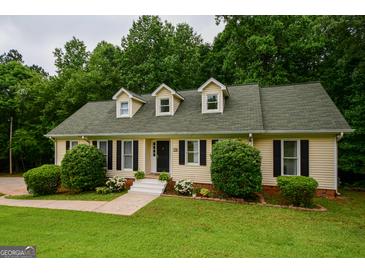 Charming single-story home featuring dormer windows, complemented by lush landscaping and a well-maintained green lawn at 170 River Forest Dr, Fayetteville, GA 30214