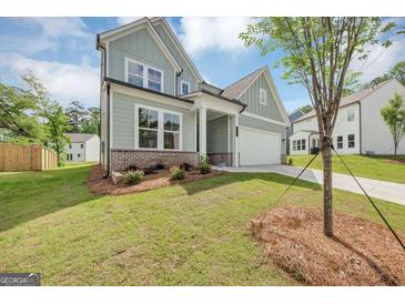 Charming two-story home with a well-manicured lawn and light blue siding, complemented by an attached two-car garage at 107 Cedar Brook Dr, Canton, GA 30115
