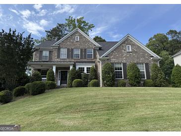 Beautiful brick home with manicured front lawn and symmetrical landscaping in a lovely neighborhood at 2750 Brentwood Estates Ct, Cumming, GA 30041