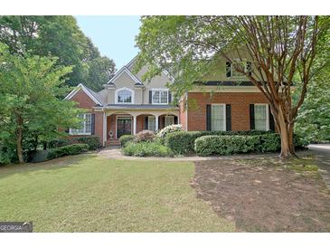 Charming two-story brick home with a manicured lawn and a welcoming front porch at 102 Passage Point, Peachtree City, GA 30269