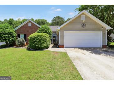 Charming single-story home with well-manicured lawn and attached two car garage at 422 Old Ivy Path, Mcdonough, GA 30253