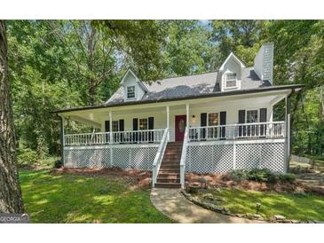 Charming home featuring a spacious wrap-around porch, black shutters, and a well-manicured lawn at 230 Vienna Way, Douglasville, GA 30134