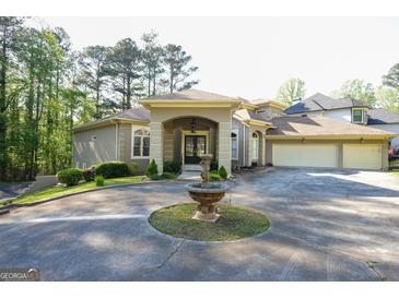 Stunning home featuring a circular driveway, fountain, and well-manicured landscaping at 1010 Forest Overlook Sw Dr, Atlanta, GA 30331