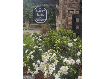 Stone entrance to Ashley Falls community with blooming flowers at 7253 Lacey Dr, Douglasville, GA 30134