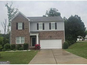 Charming two-story home with brick accents, attached garage, and well-maintained front yard at 7253 Lacey Dr, Douglasville, GA 30134