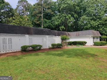 Well-maintained exterior with lush greenery and a white brick perimeter fence at 7640 Ryefield Dr, Sandy Springs, GA 30350