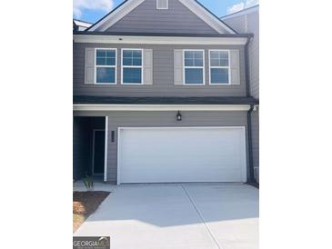 Charming two-story townhome featuring a white garage door, gray siding and white trim at 1017 Merritt Dr Edinberg Dr # 103, Villa Rica, GA 30180