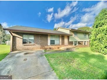 Charming single Gathering home with a brick facade and a well maintained lawn at 102 Crystal River Dr, Riverdale, GA 30274