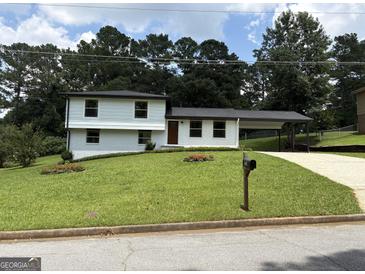 Charming two-story home with a well-manicured lawn and convenient carport at 7340 Chalk Way, Riverdale, GA 30296
