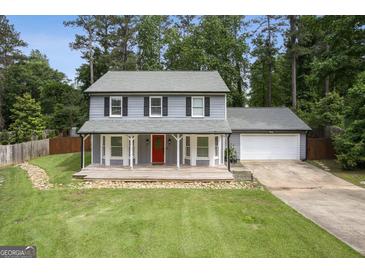 Charming gray two-story home featuring a welcoming front porch, red door, and lush green lawn at 120 Bowfin Bay, Peachtree City, GA 30269