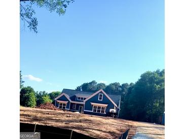 Newly constructed home with dark blue siding and white trim, situated on a spacious lot at 1273 Jersey Social Circle Rd, Covington, GA 30014
