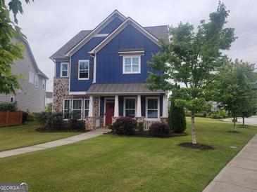 Charming two-story home with blue siding, stone accents, a manicured lawn and a welcoming red front door at 1946 Jeffery Nw Rd, Atlanta, GA 30318