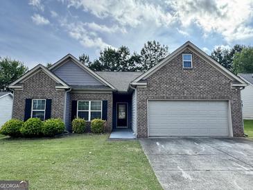 Charming single-story brick home with a well-manicured lawn, an attached two-car garage and welcoming curb appeal at 6703 Biscayne Blvd, Rex, GA 30273
