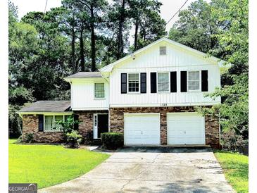 Charming two-story home with brick and white siding and a two-car garage and well maintained front lawn at 1328 Kimlie Ln, Decatur, GA 30035