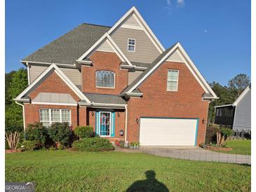 Charming two-story brick home with a manicured lawn, bright blue door, and attached two-car garage at 3932 Misty Lake, Ellenwood, GA 30294