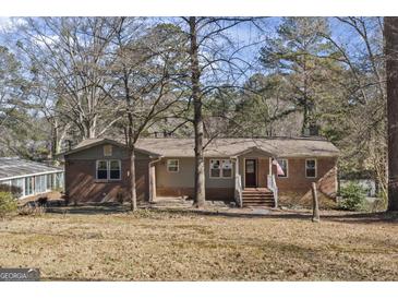 Charming single-story home featuring a brick facade, covered porch, and well-manicured yard at 2545 Rockbridge Nw Rd, Conyers, GA 30012