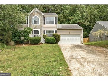 Charming two-story home with stone accents and a two-car garage nestled amongst mature trees at 1960 Morning Nw Walk, Acworth, GA 30102