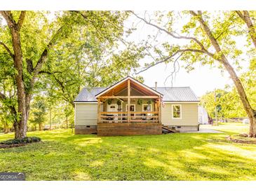 Charming home with a metal roof, inviting front porch, and a lush green lawn at 316 Gaithers Rd, Mansfield, GA 30055