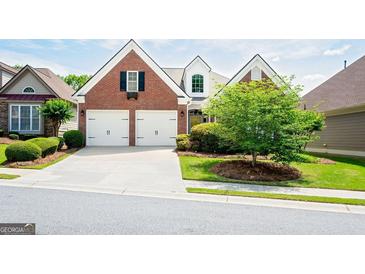 Charming brick home with a two-car garage and well-manicured lawn and landscaping at 335 Grand Teton Cir, Fayetteville, GA 30215