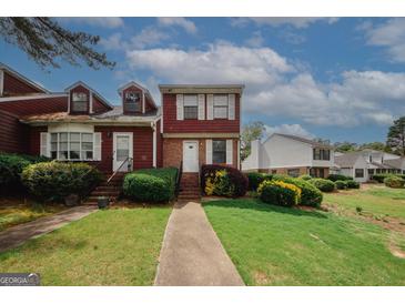 Charming townhome featuring a lush green lawn and beautiful landscaping at 5461 Park S Pl, Atlanta, GA 30349