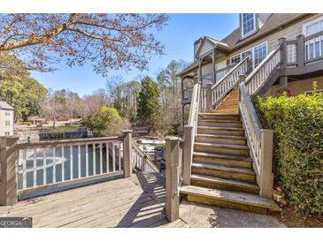 Multi-level deck overlooking peaceful lake with stairs leading up to the main house at 504 Mill Pond Se Ct, Smyrna, GA 30082