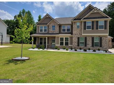 Charming two-story home featuring brick accents, a well-manicured lawn, and a welcoming covered front porch at 436 Lothbury Ave, Locust Grove, GA 30248