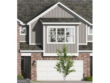 Charming townhome featuring brick accents and a two-car garage, blending modern design with classic materials at 2024 Piccolo Ct # 228, Mcdonough, GA 30252