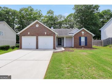Charming brick home with two-car garage, manicured lawn and mature trees at 9067 Bob Jackson Dr, Jonesboro, GA 30238