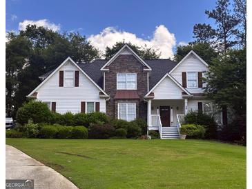 Charming two-story home with stone accents, a well-manicured lawn, and mature landscaping at 74 Flanders Ct, Douglasville, GA 30134