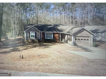 Charming single-story home featuring a one-car garage, mature trees, and a well-maintained front yard at 2291 County Line Sw Rd, Atlanta, GA 30331